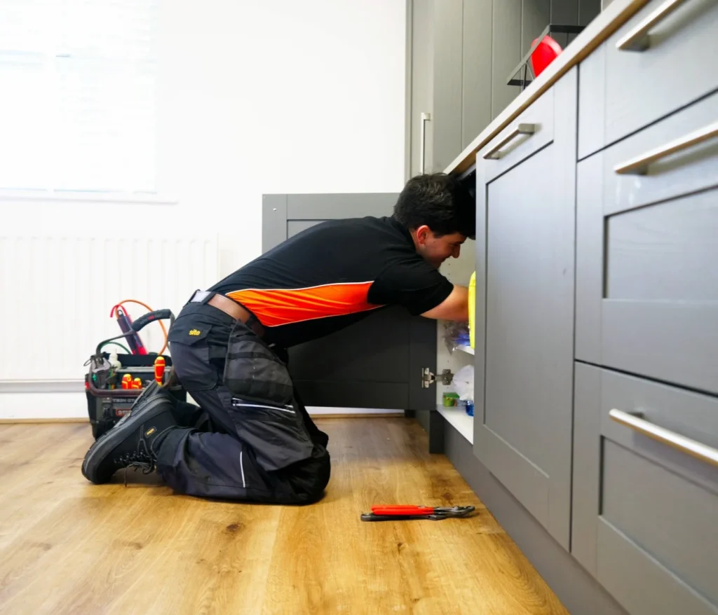 LS1 Plumbing Emergency Plumber In Leeds Fixing A Leak In A Kitchen